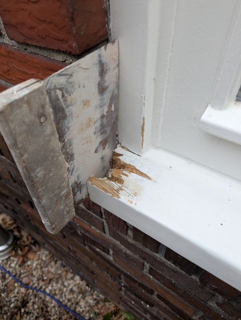 Houtrot in een raamdorpel zichtbaar na het verwijderen van de oude verf