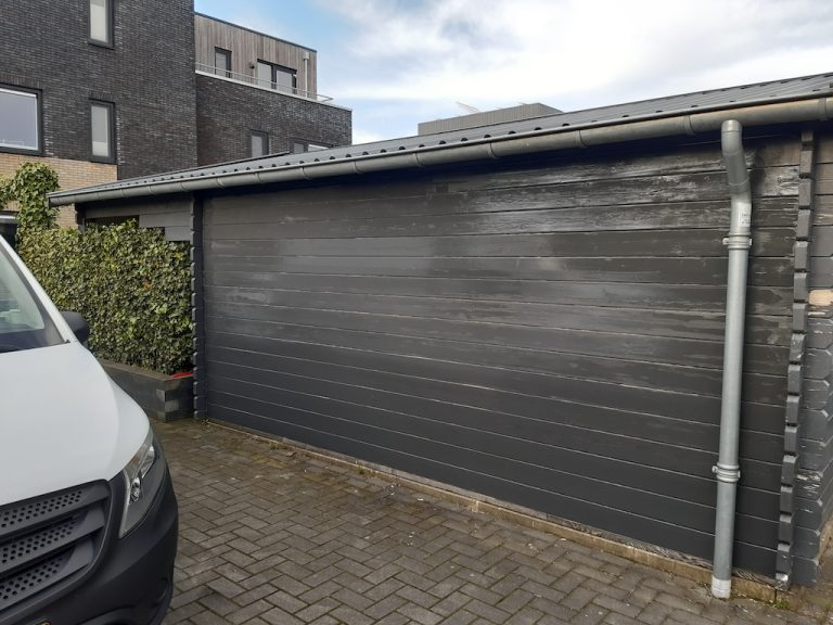 Afgewerkte donkere houten schuurgevel na behandeling