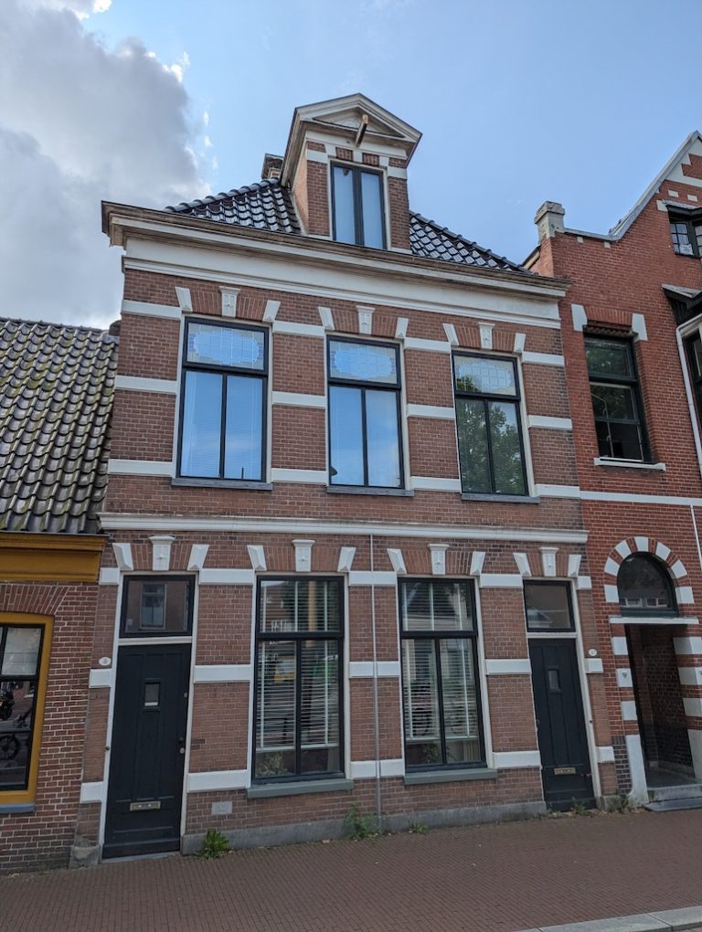 Gevel van een karakteristiek pand met wit lijstwerk