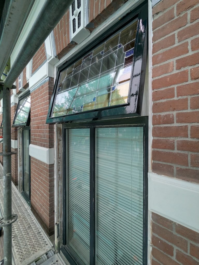 Gerestaureerd raamkozijn met glas-in-lood bovenlicht