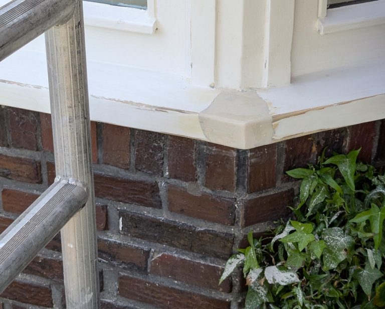 Herstelde en geschilderde kozijnhoek na houtrotreparatie