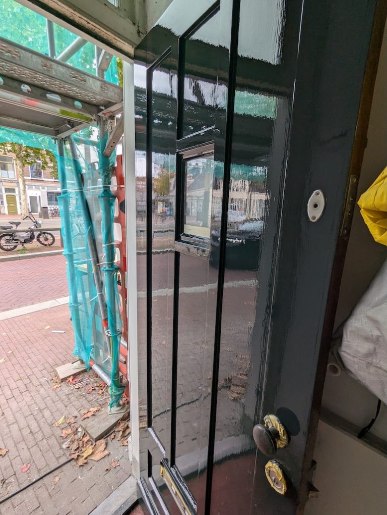 Voordeur tijdens het schilderwerk, achter de steiger