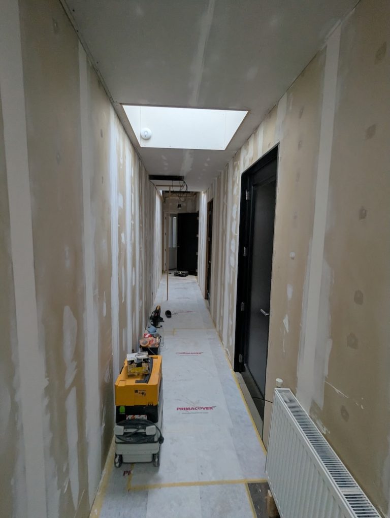 Gang van een woning tijdens de afbouw en het schilderwerk