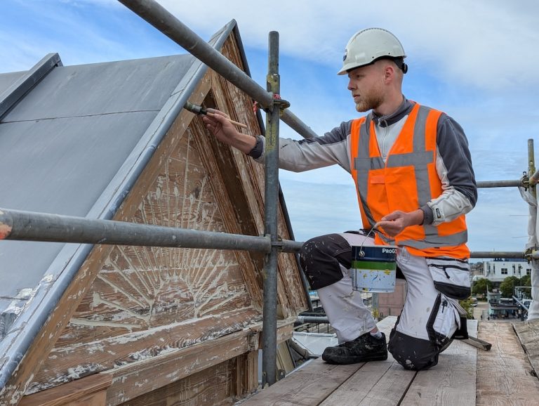 Schilder van Kuik Schilderwerk werkt op de steiger aan een topgevel