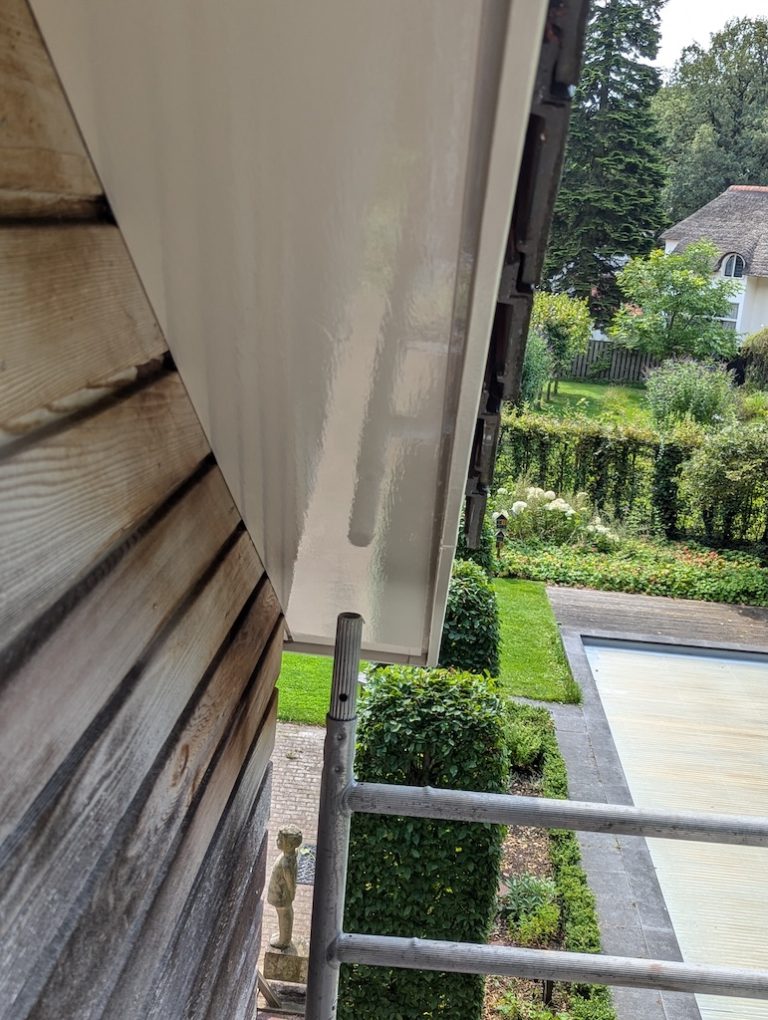 Kaal houten overstek voor behandeling, gezien vanaf de steiger