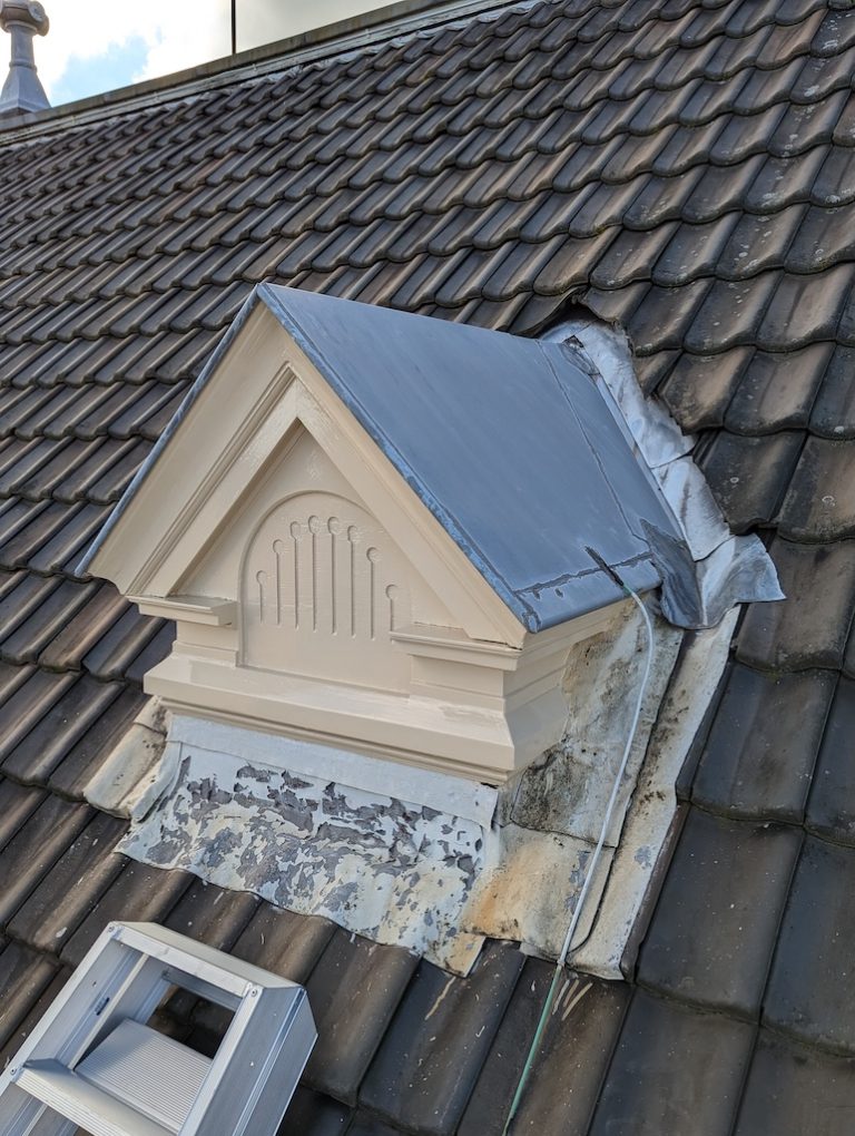 Herstelde en gelakte topgevel met ornament in crèmewit